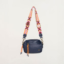 Navy leather box crossbody bag shown hanging with adjustable patterned strap in pink, orange and cream tones.