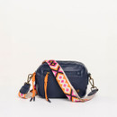 Navy leather box crossbody bag with colourful pink and orange geometric strap, featuring double front zip pockets and orange zip pulls.