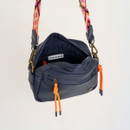 Open view of the navy box crossbody bag revealing dark lining, internal zip pocket and branded label detail.