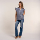 Model wearing a navy and white gingham frill sleeve blouse with blue flared jeans and wedge sandals, shown full length.