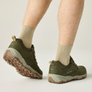 Model wearing the olive green shoes from the back, highlighting the heel pull tabs and lugged gum sole.