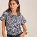 Close-up of a navy short sleeve top with blue and white floral print and shirred neckline detail.