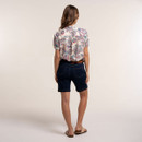 Back view of the cream paisley print blouse styled with dark denim shorts and flat sandals.
