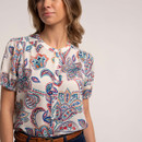 Close-up of the cream blouse showing colourful paisley print and button fastening at the front.