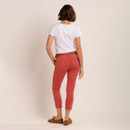 Back view of the coral cropped trousers with patch pockets, paired with a white T-shirt and brown suede loafers.