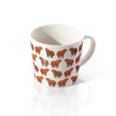 White ceramic mug featuring a pattern of small, brown Highland cows. The design is playful, creating a warm and whimsical tone against the white background.