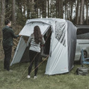 Couple setting up an Easy Camp rear awning on a campervan in a forest campsite