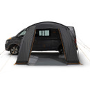 Black camping van with a large dark grey awning tent attached, pitched on a white background. The setup conveys an adventurous, outdoor vibe.