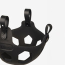 Black rubber object with hexagonal cutouts and three straps, possibly a muzzle or holder. The design is sleek and modern against a plain background.
