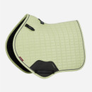 A light green, quilted horse saddle pad with black trim and logo tags is displayed against a white background, conveying a sleek and modern design.