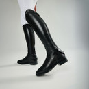 Close-up of a person wearing sleek, black leather riding boots with white pants. The boots have zippers and buttons, exuding a polished, equestrian style.