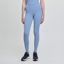 A person wearing light blue, high-waisted leggings and a matching top, with black sneakers. The background is plain light grey.