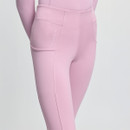 Close-up of a person wearing light pink leggings with visible seams and a small side pocket. The fabric appears soft and stretchy.