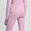Person wearing form-fitting, light pink activewear with subtle embroidered patterns on the leggings. The tone is sleek and stylish, evoking a sense of comfort and modernity.