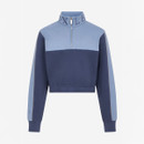 A two-toned blue cropped sweatshirt with a quarter-zip collar. The top of the collar features large lettering. The design is modern and sporty.