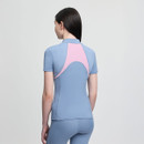 A woman with long dark hair stands facing away, wearing a light blue and pink activewear outfit. The design is sleek and modern against a plain background.