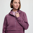 A woman in a mauve hoodie looks to the side with a gentle smile. The hoodie features a front zipper and a subtle "LeMieux" logo. The tone is casual and relaxed.