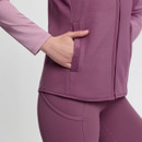 Close-up of a person wearing a mauve sports jacket and leggings, with one hand in a pocket. The tone is active and comfortable.
