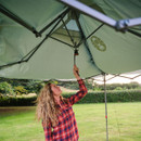 Person pulling the central strap inside the Coleman pop-up gazebo to lock the roof mechanism into place.