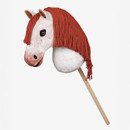 Toy stick horse with a plush white head and long red yarn mane. It has a friendly expression and is attached to a wooden stick handle.