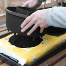 Placing the Plant Halo over a grow bag, with built-in spikes positioned to pierce the compost bag.