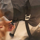 Close-up of drawstring and buckle strap on an Ooni pizza oven carry cover being tightened for a secure fit.