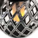 Close-up of silver lattice lantern with warm LED candle light glowing inside.