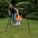 Adult pushing a baby in a Hedstrom toddler swing seat on a garden swing frame.