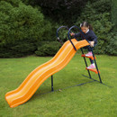 Young child climbing the ladder of a Hedstrom orange garden slide with metal frame in a backyard.