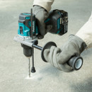 User drilling hole into concrete floor with Makita cordless hammer drill and side handle.