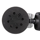 Close-up of a black circular sander pad on a tool, featuring several ventilation holes. The background shows part of the tool's body in a neutral setting.