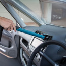 Makita portable cordless vacuum cleaning car dashboard air vents with slim nozzle attachment inside vehicle interior.