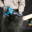 Worker cutting wood with Makita cordless reciprocating saw.