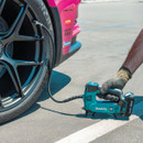 Makita 18V portable air compressor inflating a sports car tyre.