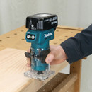 User trimming wood edge with Makita cordless router.