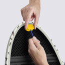 Hands adjusting the ironing board cover using a pull cord and toggle underneath.