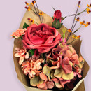 Close-up of a bouquet featuring a large red rose surrounded by peach and soft coral flowers in brown paper wrapping.
