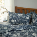 Close-up of navy woodland animal duvet cover and pillowcase, detailed deer and rabbit print bedding with botanical pattern, soft fabric texture for modern cosy bedroom styling