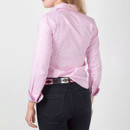 Back view of model wearing the fitted pink striped shirt with dark trousers.