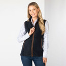 Woman wearing a navy fleece gilet with brown trim over a checked shirt, shown from the front.