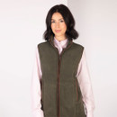 Front view of a woman wearing the khaki fleece gilet over a pale pink shirt.