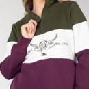 Close-up of the sweatshirt’s upper front showing the quarter zip fastening and colour block design.