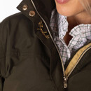 Close-up of the jacket collar and front zip fastening with embroidered logo detail and check shirt underneath.