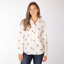 Front view of a model wearing a cream shirt with Highland cow print, styled with dark jeans.