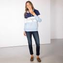 Full-length view of a model wearing a blue colour-block quarter-zip sweatshirt with Highland cow graphic, styled with jeans and brown loafers.