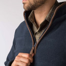 Close-up of a men’s navy overhead fleece with contrast brown trim, showing the half-zip neckline and checked shirt underneath.