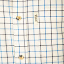 Close-up of the fabric highlighting the cream base with blue and navy check pattern, branded buttons and chest label detail.