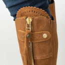 Close-up of tan suede boot upper showing gold zip, tassel pull and scalloped trim detail.
