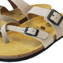 Close-up of beige suede sandal straps with black metal buckles and cushioned cork sole