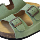 Close-up of green suede sandal straps with metal buckle fastening and textured cork footbed
